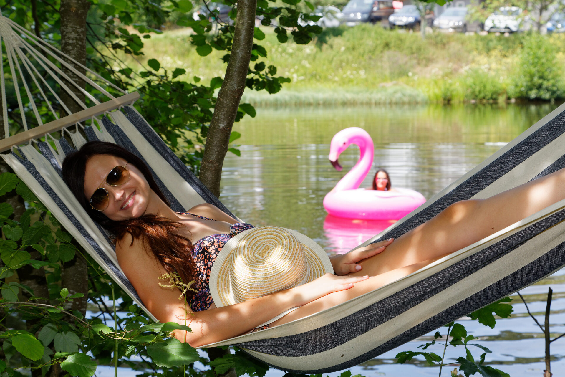 Frau entspannt in Hängematte am Naturbadeteich im Sommer Hotel Deine Auszeit im Bayerischen Wald