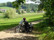 Ein Motorradfahrer macht eine Pause auf einem Feldweg im Bayerischen Wald.